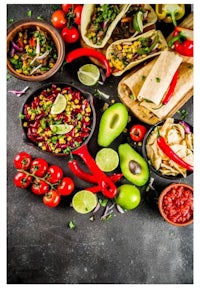 a variety of mexican food on a dark background